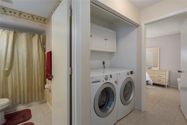 washroom with light tile patterned floors and washer and clothes dryer