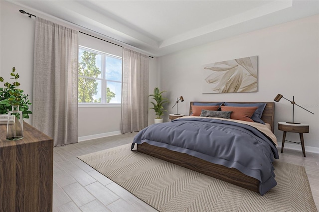 bedroom featuring light hardwood / wood-style floors and a tray ceiling