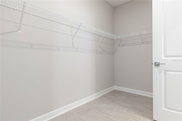 spacious closet with light hardwood / wood-style flooring