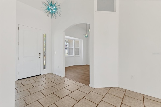 foyer entrance featuring arched walkways and light tile patterned floors