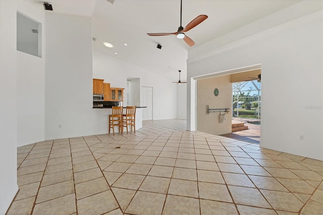 empty room with ceiling fan and high vaulted ceiling