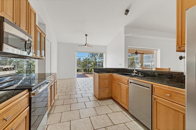 kitchen with appliances with stainless steel finishes, a ceiling fan, a sink, and a peninsula