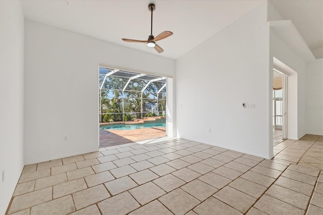 unfurnished room with a sunroom, a ceiling fan, vaulted ceiling, and tile patterned flooring