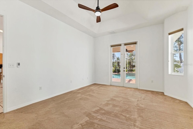 unfurnished room with light carpet, french doors, ceiling fan, and baseboards
