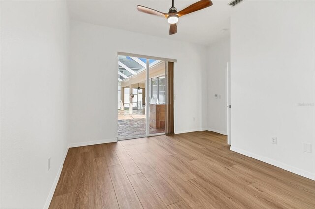 spare room with wood finished floors, baseboards, and ceiling fan