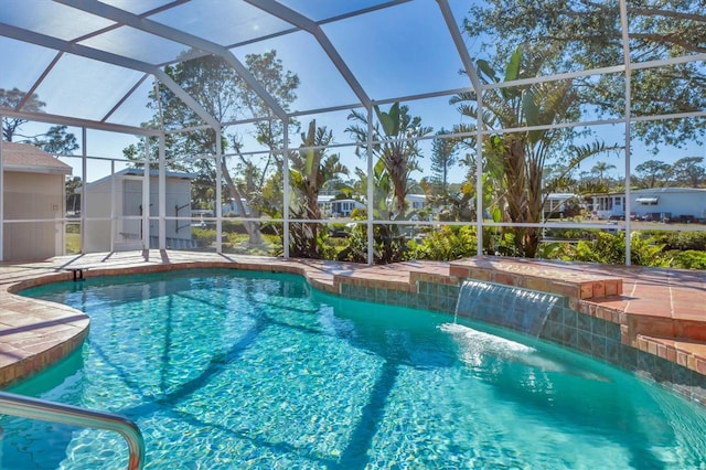outdoor pool with a storage shed, an outbuilding, glass enclosure, and a patio area