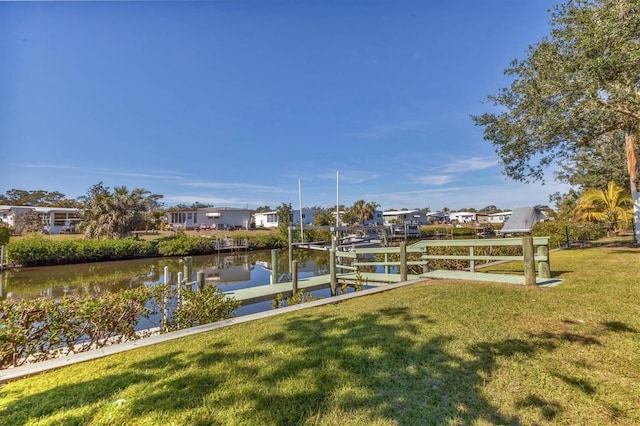 dock with boat lift, a water view, a yard, and a residential view