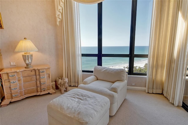 living area with a water view and light carpet