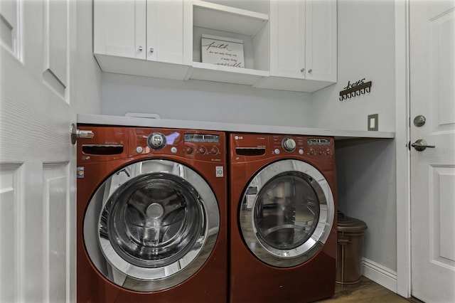 washroom with cabinets, separate washer and dryer, and hardwood / wood-style flooring