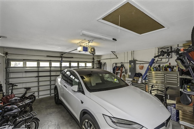 garage with a garage door opener and electric panel