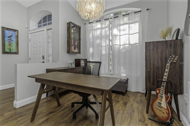 home office with dark wood-type flooring and an inviting chandelier