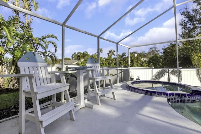 view of patio / terrace with an in ground hot tub and glass enclosure