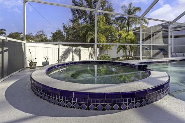 view of swimming pool featuring an in ground hot tub and glass enclosure