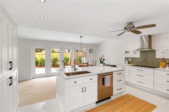 kitchen with sink, wall chimney range hood, stainless steel dishwasher, black electric stovetop, and white cabinets