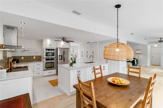 dining space featuring ceiling fan, sink, and light hardwood / wood-style flooring