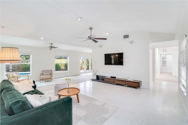 living room featuring ceiling fan, lofted ceiling, and a healthy amount of sunlight