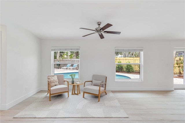 living area with ceiling fan and light wood-type flooring