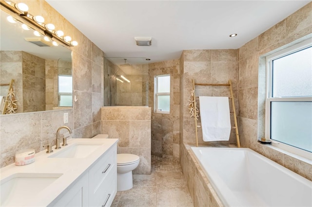 full bathroom featuring toilet, independent shower and bath, tile walls, and a wealth of natural light