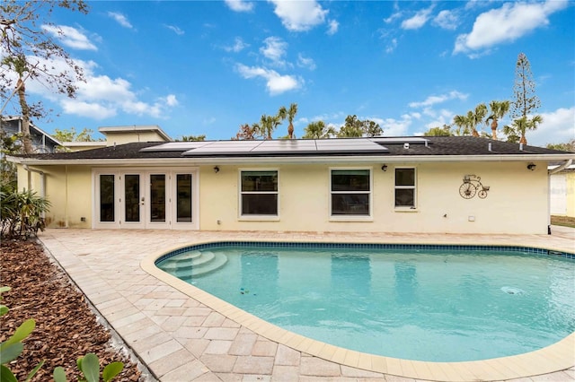 view of pool with a patio area and solar panels