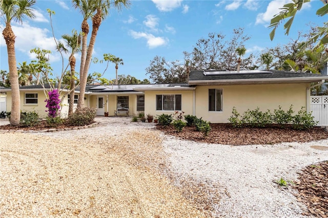 ranch-style home featuring solar panels