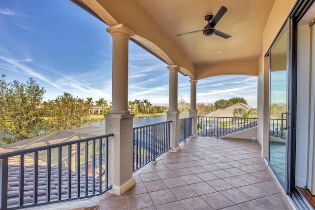 balcony with a water view and a ceiling fan