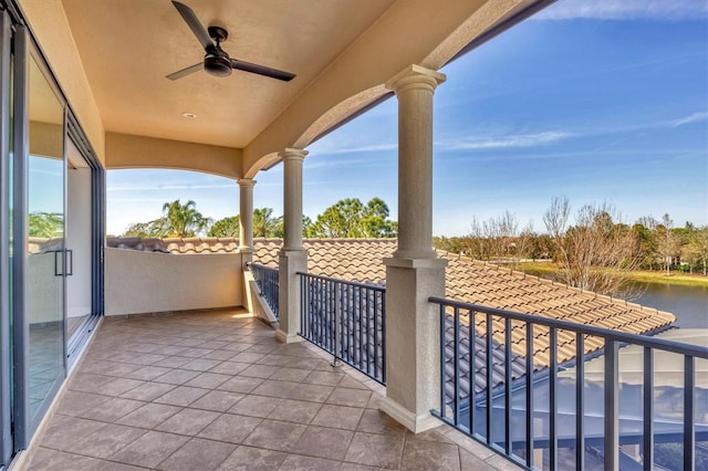 balcony featuring a water view and a ceiling fan