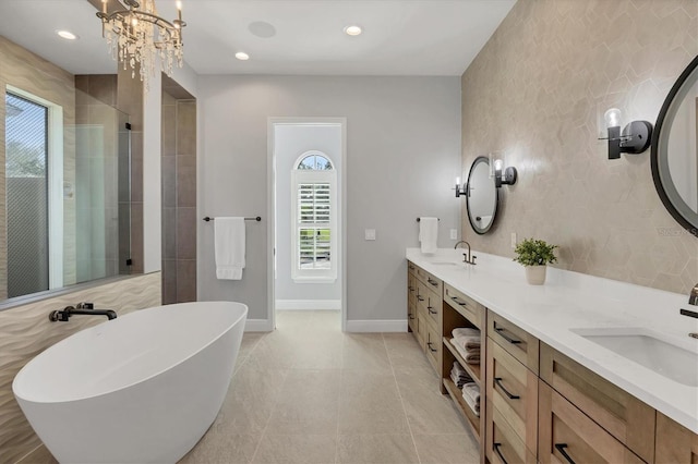 full bath with a sink, a shower stall, baseboards, and double vanity