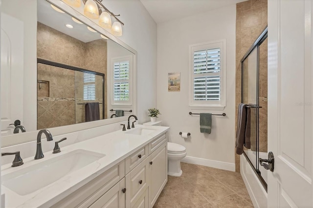 full bath with double vanity, tiled shower / bath combo, a sink, and baseboards