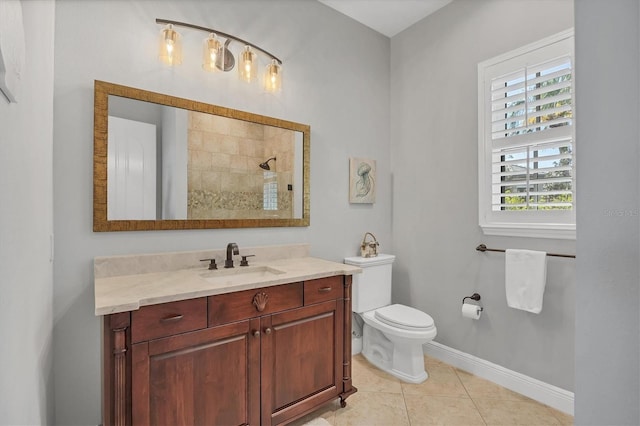 bathroom featuring baseboards, toilet, tile patterned flooring, a tile shower, and vanity