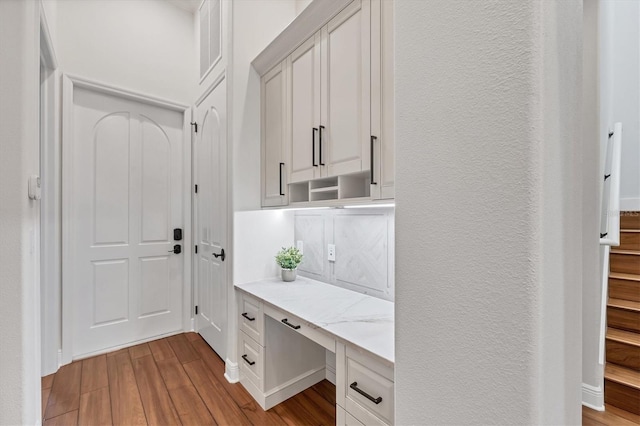 mudroom featuring a textured wall, visible vents, wood finished floors, and built in study area