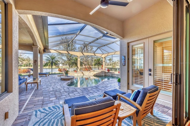 view of patio / terrace featuring a lanai, a ceiling fan, and an outdoor pool