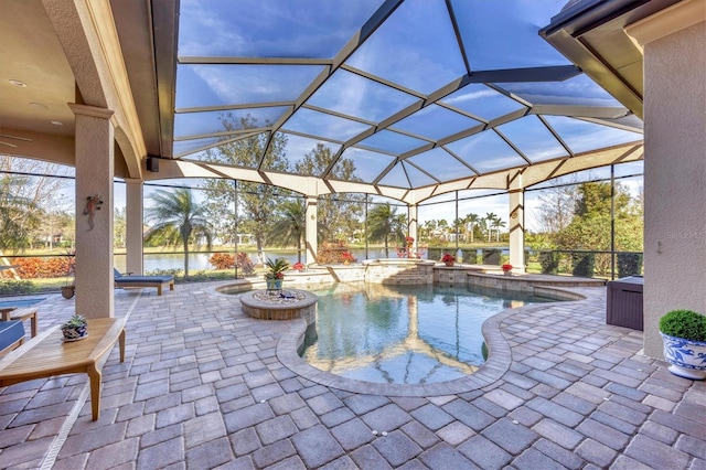 exterior space with glass enclosure, a pool with connected hot tub, and a patio area