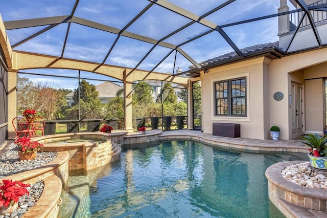 view of pool with a lanai, a pool with connected hot tub, and a patio