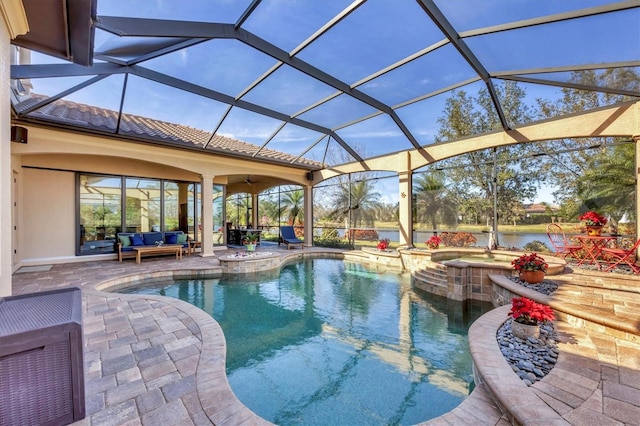 outdoor pool with an in ground hot tub, glass enclosure, a patio, and an outdoor hangout area