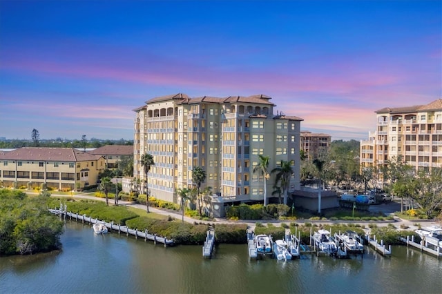 property at dusk featuring a water view