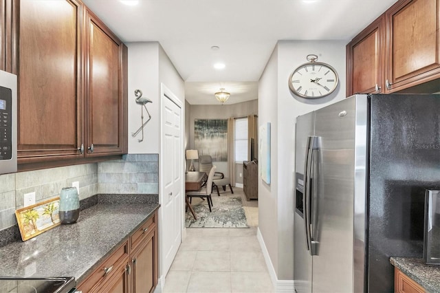 kitchen featuring brown cabinets, tasteful backsplash, light tile patterned flooring, and stainless steel fridge with ice dispenser