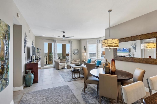 dining space with light tile patterned floors, visible vents, baseboards, and a ceiling fan