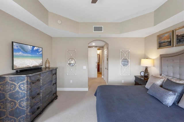 carpeted bedroom with visible vents, arched walkways, and baseboards