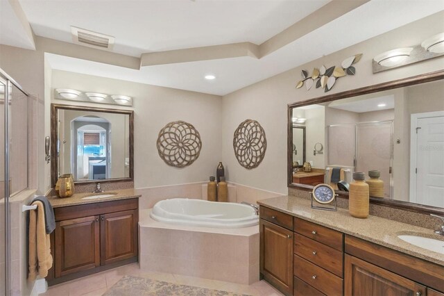 full bath with tile patterned flooring, a stall shower, a garden tub, and a sink