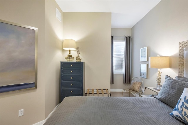 bedroom featuring baseboards and visible vents