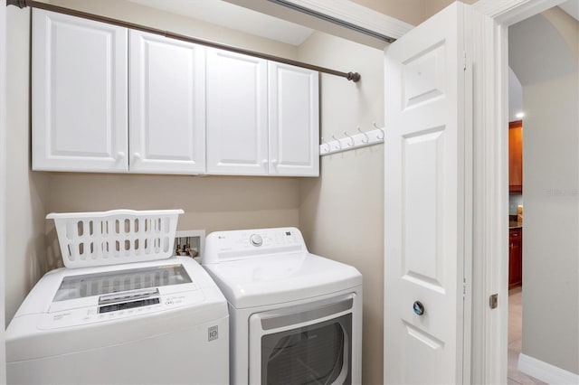 laundry area with cabinet space and separate washer and dryer