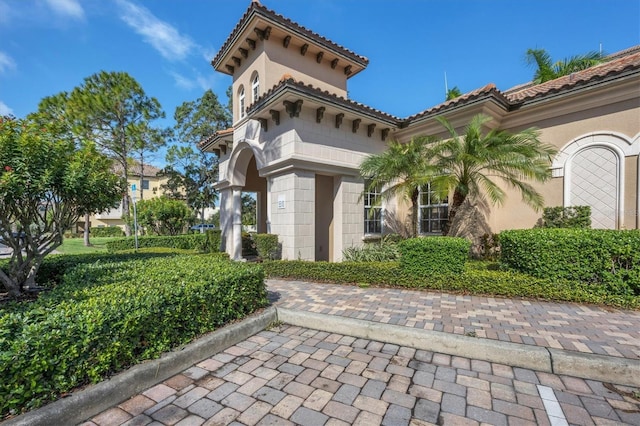 exterior space with a tiled roof and stucco siding