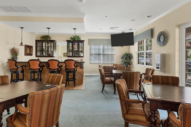 dining space with a community bar, carpet, visible vents, and ornamental molding