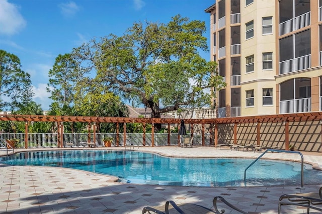 community pool with a patio area and fence