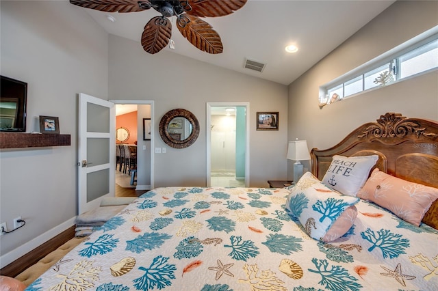 bedroom featuring lofted ceiling, connected bathroom, light hardwood / wood-style floors, and ceiling fan