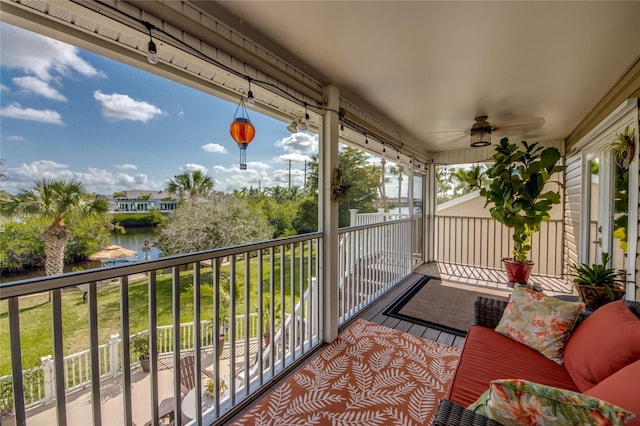 balcony with a water view and ceiling fan