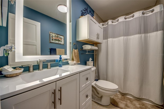 bathroom featuring vanity, tile patterned floors, and toilet