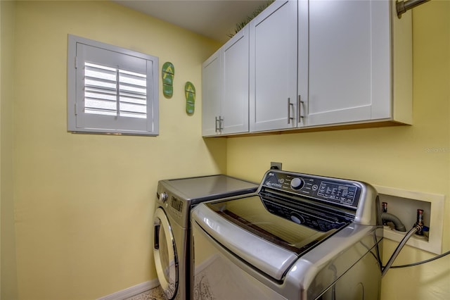 laundry room featuring cabinets and washer and clothes dryer