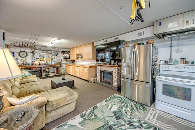 kitchen featuring light brown cabinetry, tile counters, stainless steel fridge, white range with electric cooktop, and carpet