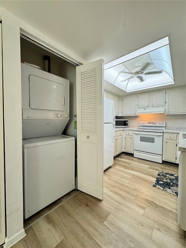 laundry room featuring stacked washer and dryer and light hardwood / wood-style flooring